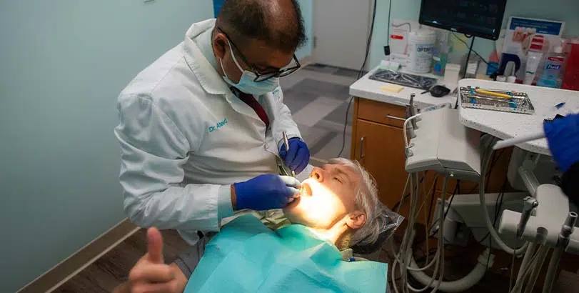 Dr. Ahmed performing a dental procedure on a new patient in Rocky Hill, CT